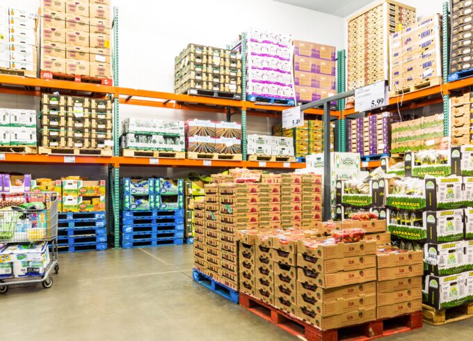 A photograph of a Costco cooler room full of pallets with produce in them.