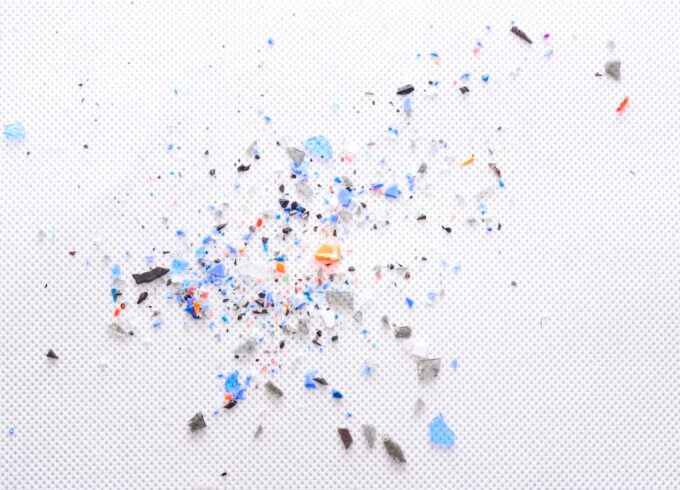 A white paper with bits of multi colored microplastics on top of it.