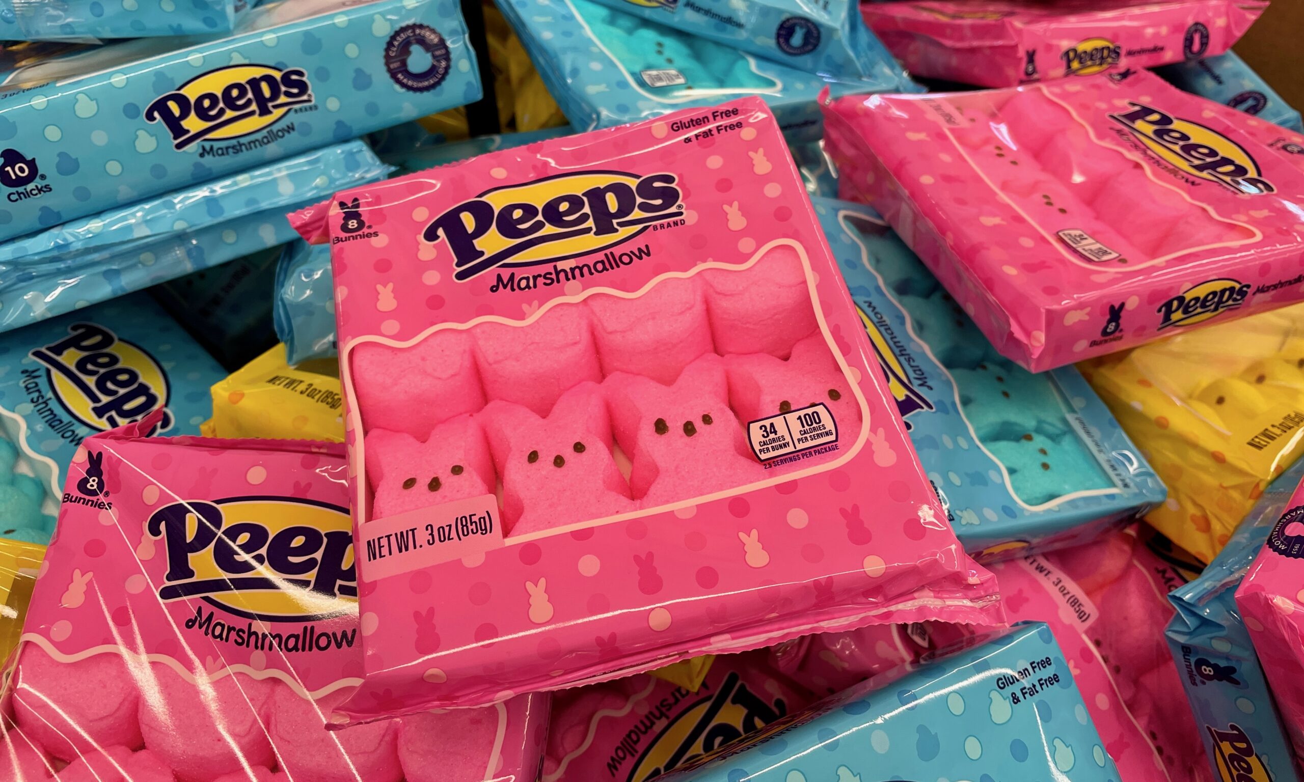 A photograph of a pile of Peeps packages, both pink and blue.