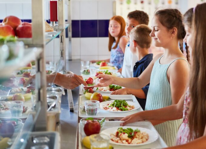 Group of children as elementary students at buffet line, enjoying variety of food options