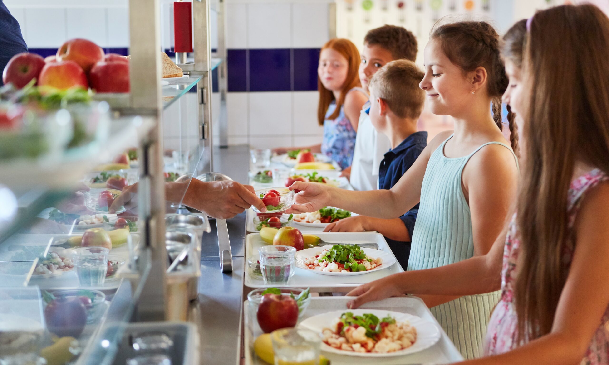 Group of children as elementary students at buffet line, enjoying variety of food options