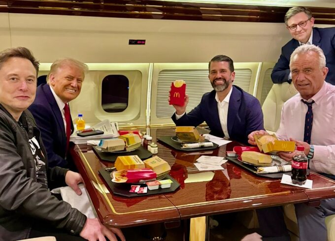 A photograph of Elon Musk, Donald Trump, Donald Trump Jr., and Robert F. Kennedy Jr. sitting with McDonald's.